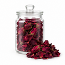 Dried red rose buds and petals in a clear jar on a white background