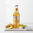 Fever-Tree Ginger Beer bottle with fresh ginger and lime on white marble