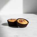 Brooklyn Born Chocolate Cashew Butter Cups — dark chocolate cups with cashew butter filling on white marble