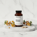 Genestra Berberis Formula herbal supplement bottle on marble surface with berberis botanical accents