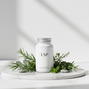 Genestra LSP herbal supplement bottle on white marble surface with botanical accents