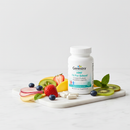 Genestra HMF Fit For School probiotic supplement bottle on marble surface with fruit and botanical accents