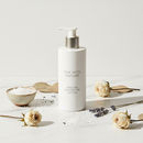 One With Nature Dead Sea Shea Butter Lotion 350mL on marble surface with botanical accents