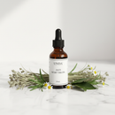 Unda Anti Wort Drops 20mL bottle on marble surface with botanical accents
