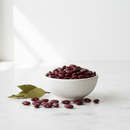 Organic dark red kidney beans in a ceramic bowl on white marble surface