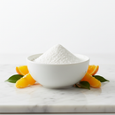 Pure Ascorbic Acid Vitamin C powder in a white ceramic bowl on marble with orange slices and botanical accents