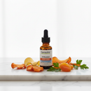 Genestra A Mulsion vitamin A liquid supplement dropper bottle on marble surface with carrot and botanical accents