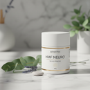Genestra HMF Neuro Powder 60g supplement jar on marble surface with botanical accents