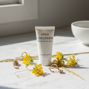 Unda Cheliderm Cream tube on marble with greater celandine botanical accents