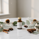 Unda Mucococcinum amber bottle on marble with winter botanical accents