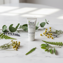 Unda Proctosan Cream tube on marble with soothing botanical accents