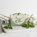 Living Clay Bar Soap Mint on marble surface with fresh mint leaves
