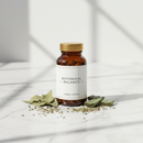 Genestra Herbolax herbal supplement bottle on white marble surface with botanical accents