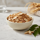 Canadian Panax ginseng root, whole cut and sifted, in a ceramic bowl on white marble surface with botanical accents