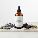Genestra Colloidal Multi Mins Liquid mineral supplement bottle on marble surface with mineral stones and botanical accents
