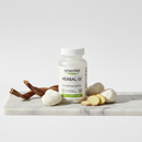 Genestra Herbal GI supplement bottle on marble surface with botanical accents