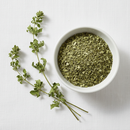 Dried cleavers herb cut and sifted in a white ceramic bowl on white background