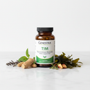 Genestra TIM thyroid immune modulator supplement bottle on marble surface with ashwagandha and seaweed botanical accents