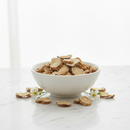 Dong Quai root cut and sifted pieces in a white ceramic bowl on marble with dried root slices and white flowers