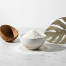 Organic coconut flour in a ceramic bowl on white marble surface