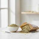 Dried oatstraw herb cut and sifted in a ceramic bowl on white marble surface